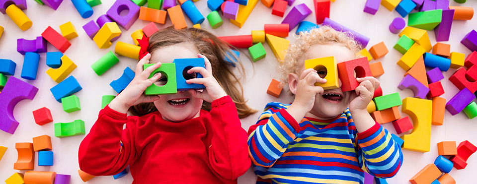 Photo of young kids playing with colorful blocks.